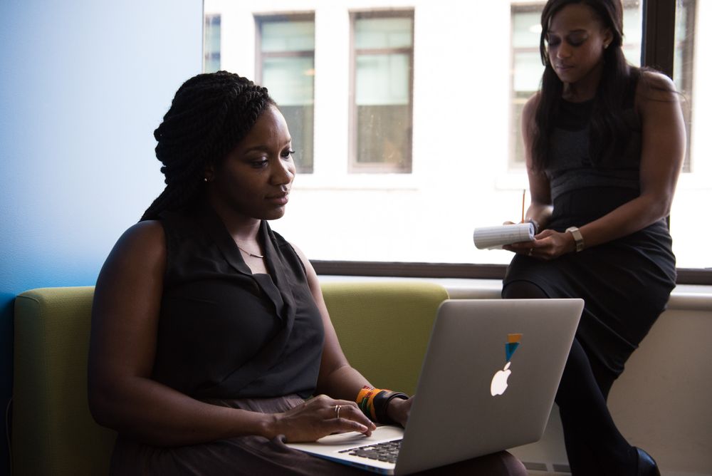 Colleagues discussing work together with a laptop